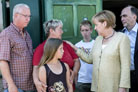 Bundeskanzlerin Angela Merkel im Gesprch mit einer Familie, deren Haus vom Hochwasser stark beschdigt wurde, 23.07.2013,  Jesco Denzel, BPA Bund