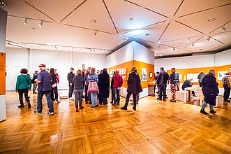 Besucher*innen in einem Ausstellungsraum.