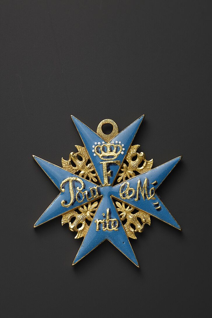 Ordensabzeichen in Blau und Gold.