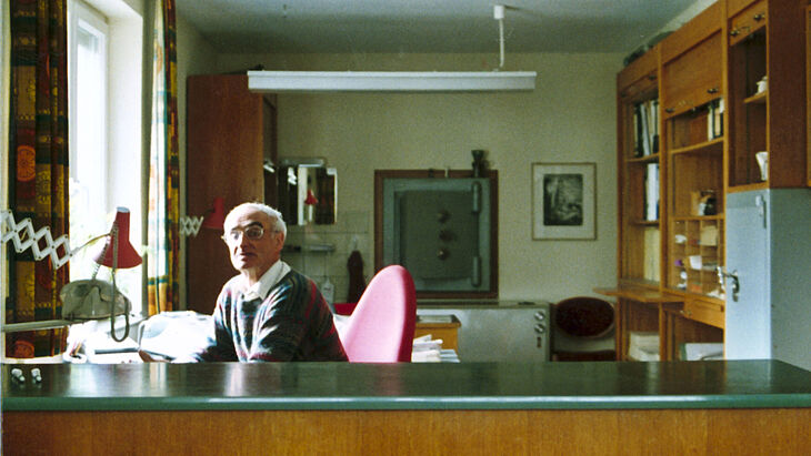 Ein Mann, der hinter einer Theke sitzt.