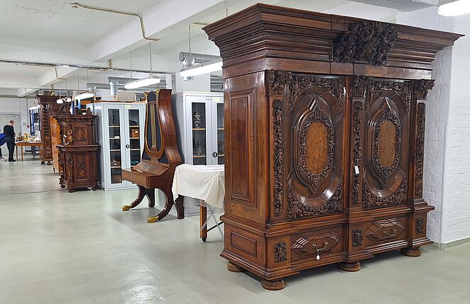 Blick ins Depot, zu sehen ist ein alter Schrank und weitere Möbel
