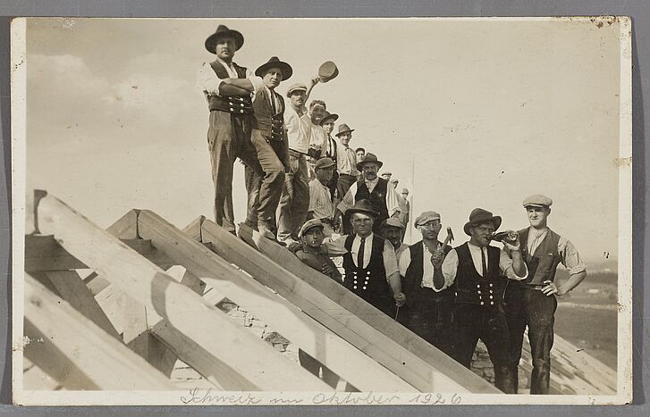 Handwerker stehen auf einem Dachstuhl