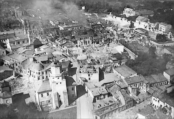 A black-and-white aerial photograph shows a destroyed city.