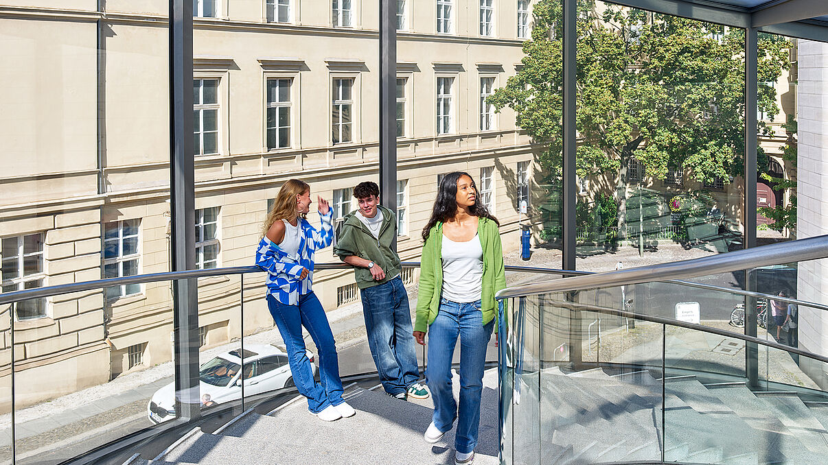 Drei jugendliche Personen stehen in einem Museum