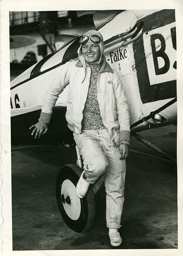 Eine Frau, die an einem Flugzeug lehnt.