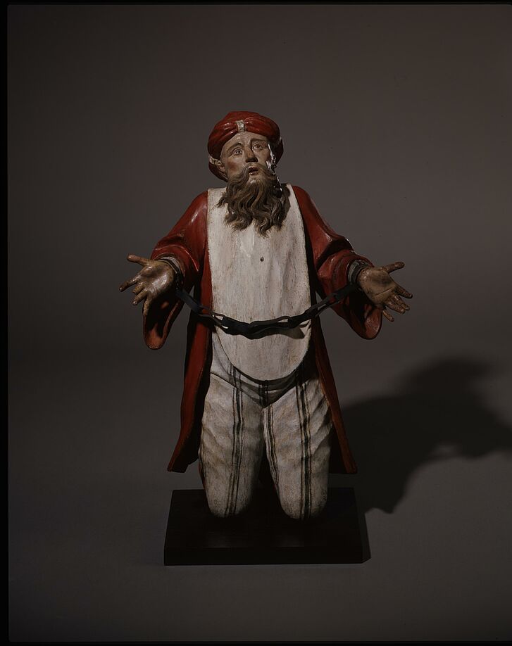 Figur eines Gefangenen in Ketten.
