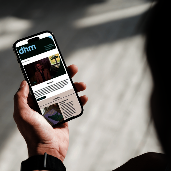 Eine Person hält ein Smartphone in der Hand und betrachtet den Newsletter des Museums.