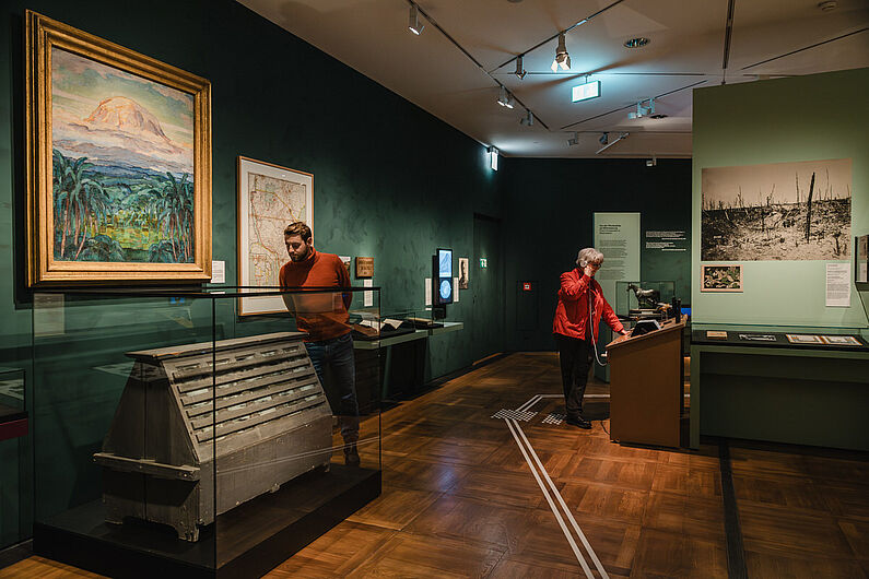 In der Ausstellung „Natur und deutsche Geschichte. Glaube – Biologie – Macht” Menschen stehen in einer Ausstellung