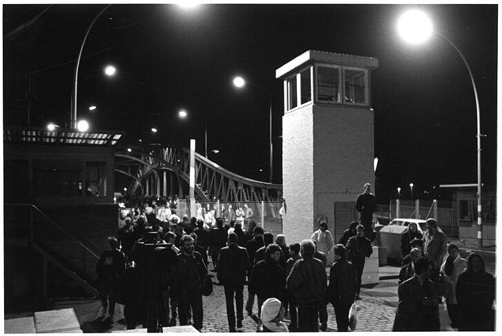 Menschen laufen durch einen offenen Teil der Mauer.