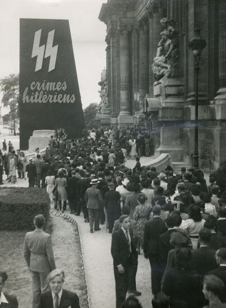 Visitors at the entrance of the exhibition “Crimes hitlériens” (Hitlerian Crimes) in the Grand Palais, Paris, 1945, reproduction © Service historique de la Défense Visitors at the entrance of the exhibition “Crimes hitlériens” (Hitlerian Crimes) in the Grand Palais, Paris, 1945, reproduction © Service historique de la Défense