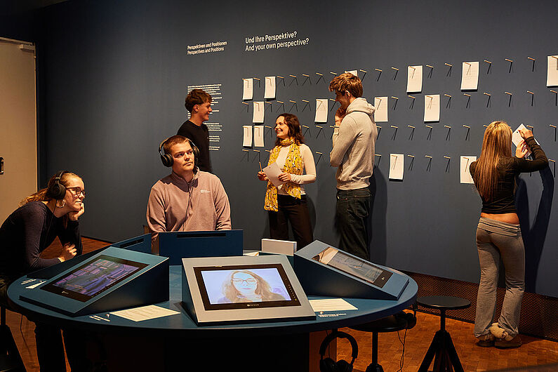 Menschen stehen in einer Ausstellung