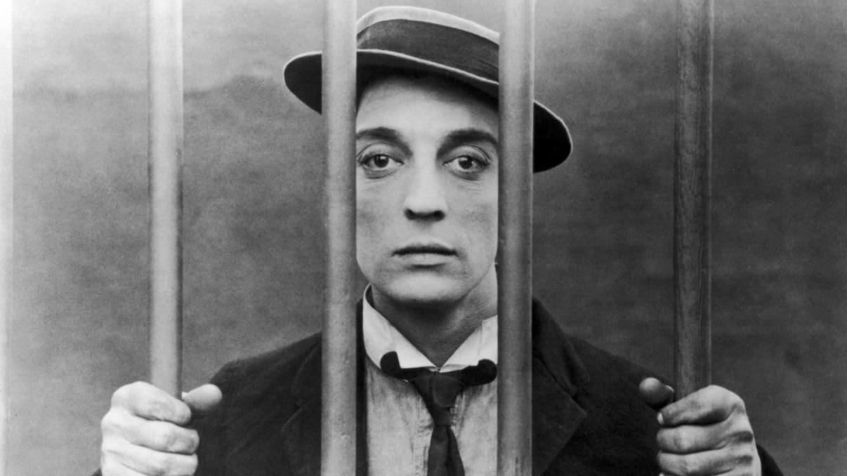 Ein Mann hinter Gittern blickt in die Kamera.