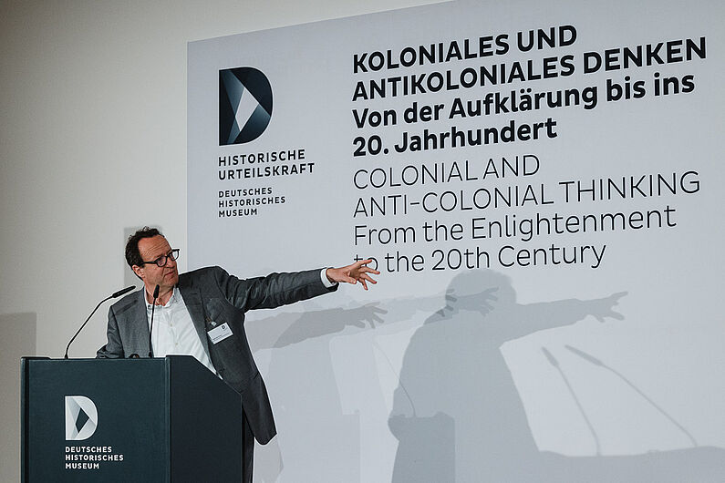 Raphael Gross steht hinter einem Pult und spricht.