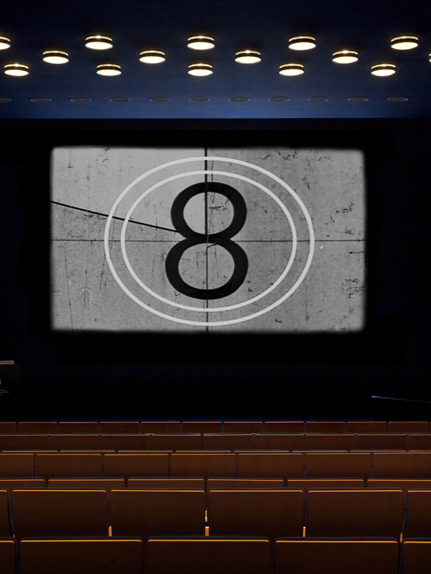 Ein leerer Kinosaal mit einer 8 auf der Leinwand.
