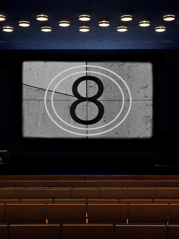 Ein leerer Kinosaal mit einer 8 auf der Leinwand.