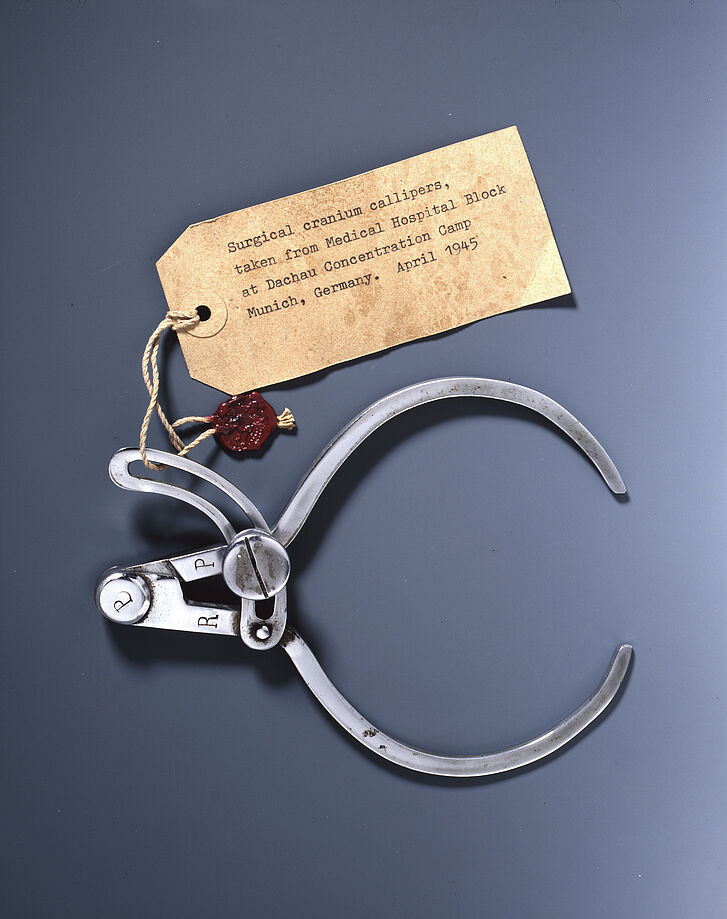 Ein Tasterzirkel vor dunklem Hintergrund.
