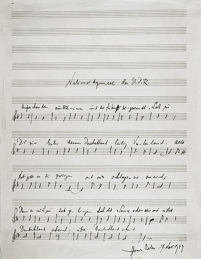 Text-Noten-Blatt der DDR-Nationalhymne, 07.11.1949. Am 10. Oktober 1949 beauftragte Pieck den Schriftsteller Johannes R. Becher, eine Nationalhymne zu verfassen. Nach mehreren Entwürfen entstand das Lied „Auferstanden aus Ruinen“, das die Situation des Jahres 1949 wiederspiegelt. Der Schönberg-Schüler Hanns Eisler vertonte es. Am 5. November 1949 bestätigte der Ministerrat die Nationalhymne. Die feierliche Erstaufführung fand am 7. November 1949 bei einem Festakt anlässlich des Jahrestages der Oktoberrevolution statt. (Inv.Nr. Do 58/82)