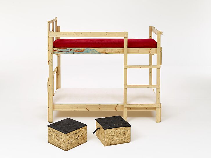 Ein einfaches Doppelstockbett aus Holz und zwei Holzkisten