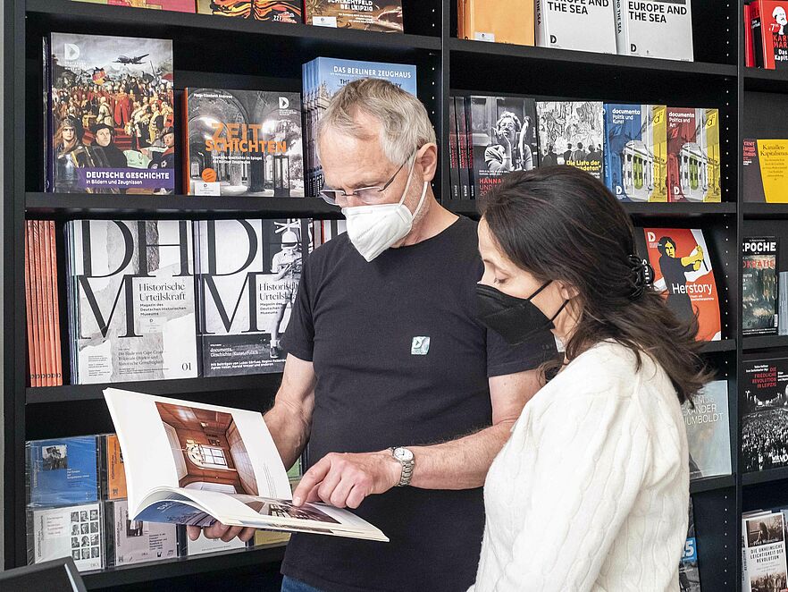 Zwei Personen betrachten ein Buch im Museumsshop