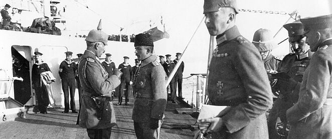 Kaiser Wilhelm II. im Gespräch mit Kriegsminister Enver Pascha auf einem Schiff mit Matrosen und Soldaten.
