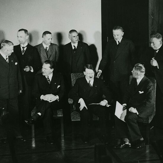 Eine Versammlung von Männern in Anzügen in einem Raum.