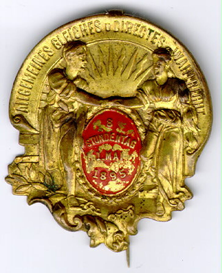 Abzeichen der SPD von 1895 mit zwei Menschen, die sich die Hand geben.