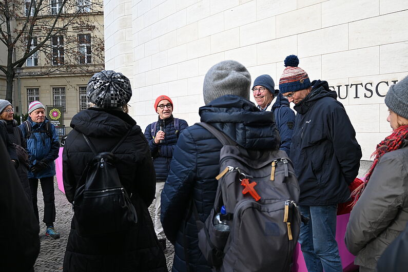 Eine Gruppe steht vor dem Museum und unterhält sich.