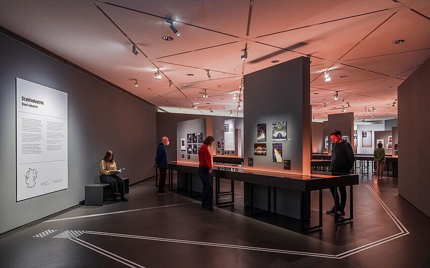 Personen schauen sich die Ausstellung an.