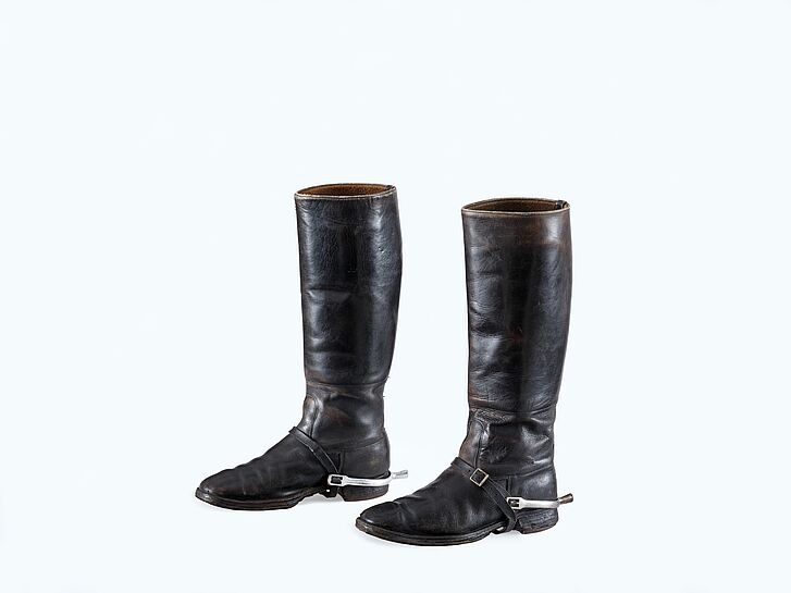 Two black leather boots with buckles and spurs.