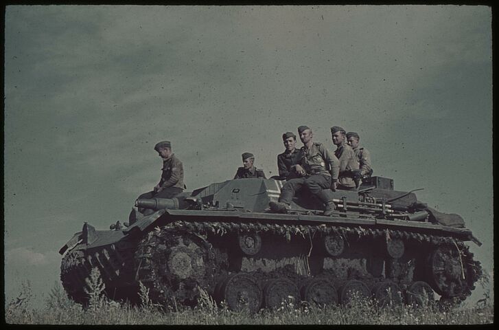 Soldaten sitzen auf einem Panzer.