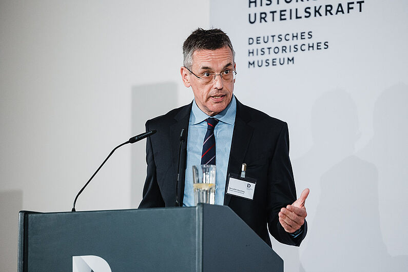Benedikt Stuchtey steht hinter einem Pult und spricht.