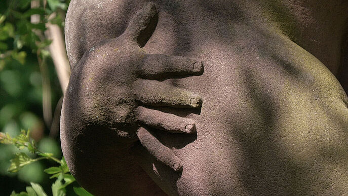 Nahansicht der Hand einer Skulptur.