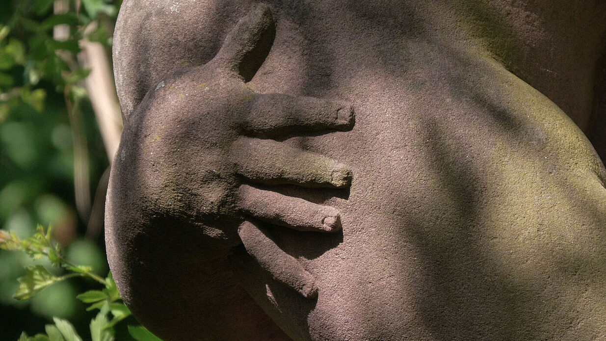 Nahansicht der Hand einer Skulptur.