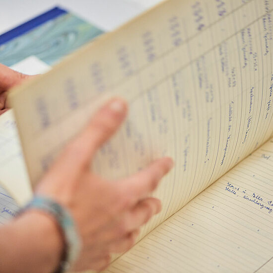 Ein Inventarbuch, indem geblättert wird.