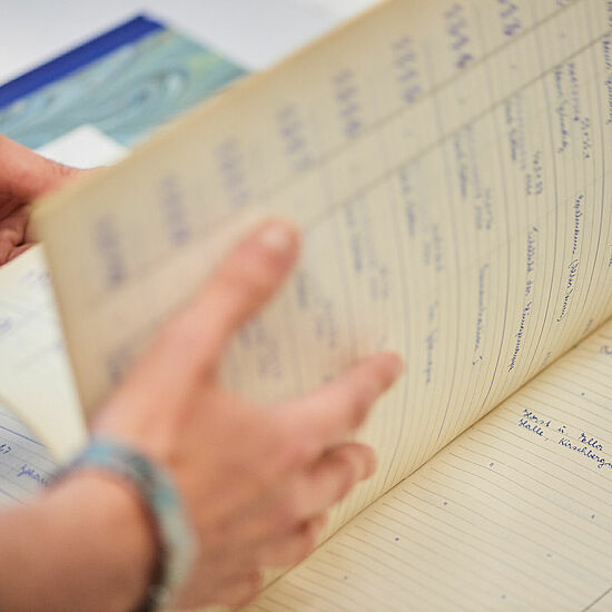 Ein Inventarbuch, indem geblättert wird.