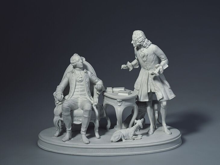 Skulpturengruppe von zwei Männern in historischer Kleidung mit Hund.