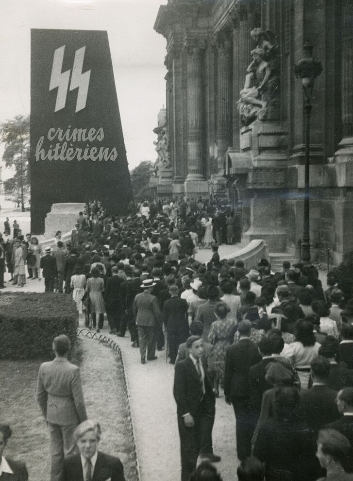 Besucherinnen und Besucher vor dem Eingang zur Ausstellung „Crimes hitlériens“ („Hitlerische Verbrechen“) im Grand Palais, Paris, 1945, Reproduktion © Service historique de la Défense Besucherinnen und Besucher vor dem Eingang zur Ausstellung „Crimes hitlériens“ („Hitlerische Verbrechen“) im Grand Palais, Paris, 1945, Reproduktion © Service historique de la Défense
