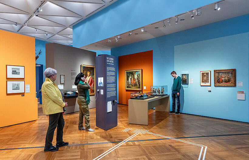 Personen schauen sich die Ausstellung an.