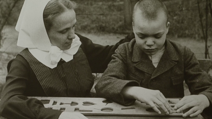 Eine Frau und ein Junge spielen mit Objekten.