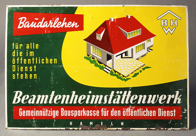 Werbeschild „Beamtenheimstättenwerk BHW“, 1950-1969. 1953 zählte das BHW 26.000 Bausparer, vier Jahre später bestanden über 100.000 Verträge. Nach 1945 waren die Beamtenorganisation des DGB und der Deutsche Beamtenbund Gesellschafter dieser Bausparkasse. (Inv.Nr. AK 2000/59)