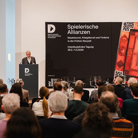 Thomas Weißbrich steht hinter einem Pult und spricht zum Publikum.