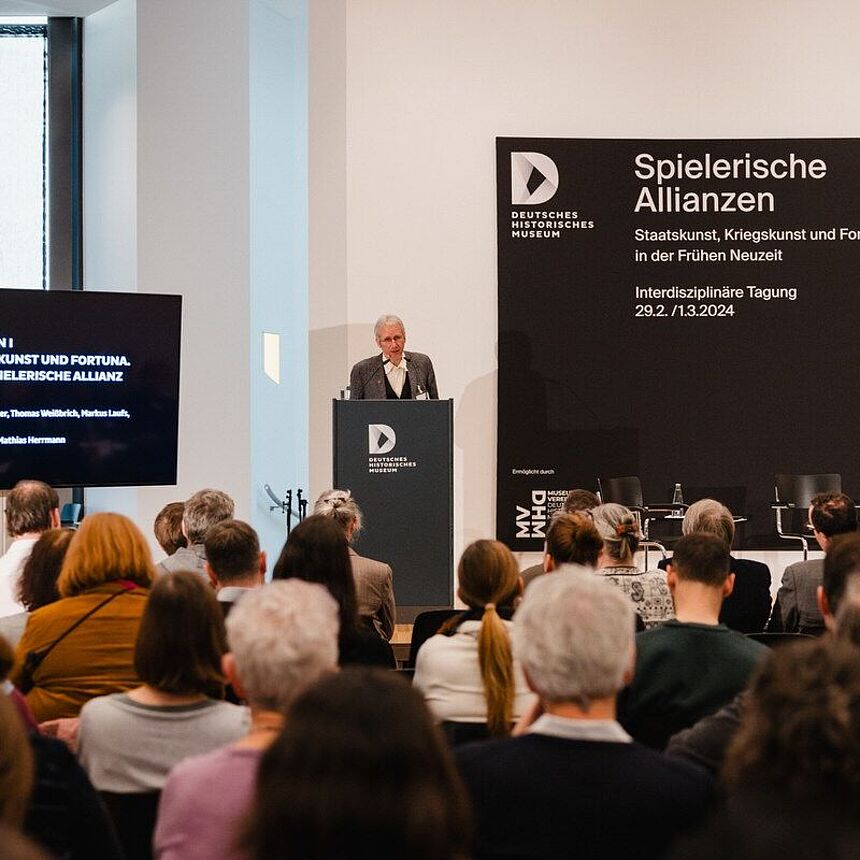 Thomas Weißbrich steht hinter einem Pult und spricht zum Publikum.