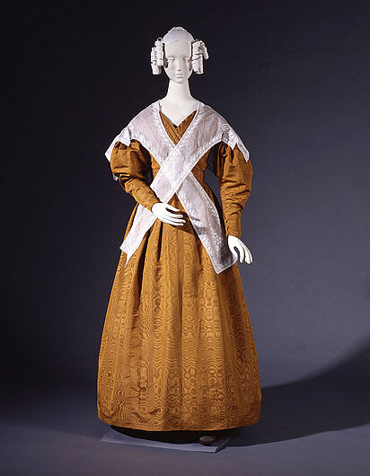 Damenkleid, um 1836. Um 1830 hatte sich die Silhouette der Frauenmode entscheidend verändert. Die Frauen trugen wieder Korsett und Keulenärmel wie im Barock. Dies ließ die schmale Taille noch zerbrechlicher wirken. (Inv.Nr. KT 99/350)