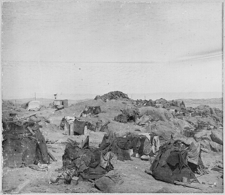 Black-and-white-photo of a landscape with tents.