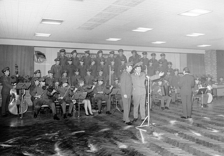 Menschen in Uniformen spielen verschiedene Instrumente und singen.