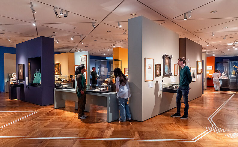 Personen schauen sich die Ausstellung an.