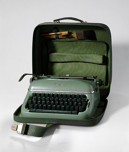 Kleinschreibmaschine „Optima Elite 3“ mit Reinigungszubehör, ab 1955. Kleinschreibmaschine „Optima Elite 3“ mit Reinigungszubehör, ab 1955. Die Schreibmaschine war ein „Messe- und Exportschlager“. Das Optima-Werk zeigte sie auf den Leipziger Messen und auf anderen internationalen Ausstellungen in Singapur, Kairo oder Düsseldorf. (Inv.Nr. HI 90/21)