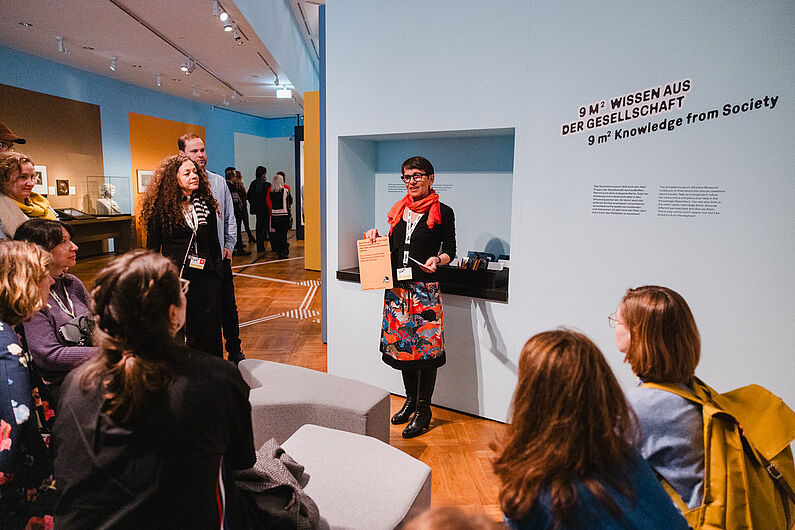Eine Gruppe von Menschen betrachtet eine Ausstellung in einem Museum.