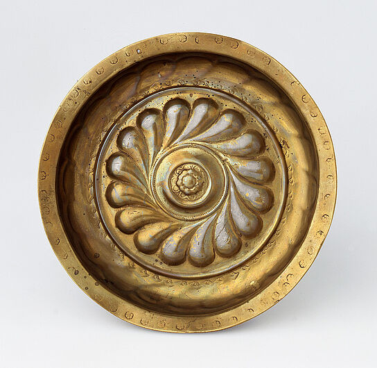 Beckenschlägerschüssel, um 1520. Beckenschlägerschüssel, um 1520. Gebrauchsgeräte aus Metall, insbesondere aus Messing, waren bedeutende Erzeugnisse spätmittelalterlichen Handwerks. Europäische Zentren der Herstellung waren Braunschweig, Nürnberg und Dinant. (Inv.Nr. AK 2001/811)