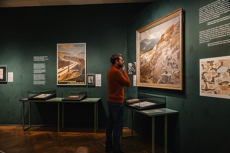 In der Ausstellung „Natur und deutsche Geschichte. Glaube – Biologie – Macht” Menschen stehen in einer Ausstellung